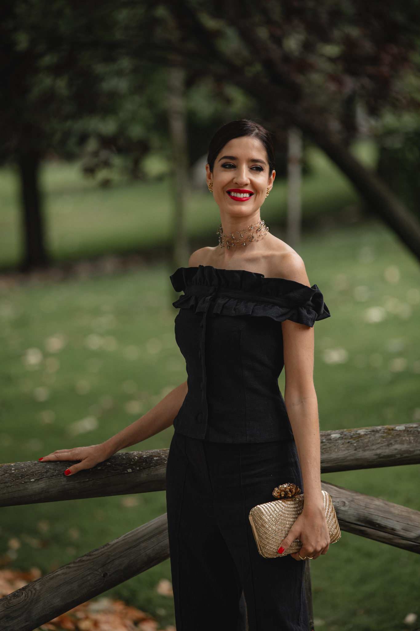 Invitada sonriente apoyada en una valla de madera con el conjunto de Cherubina