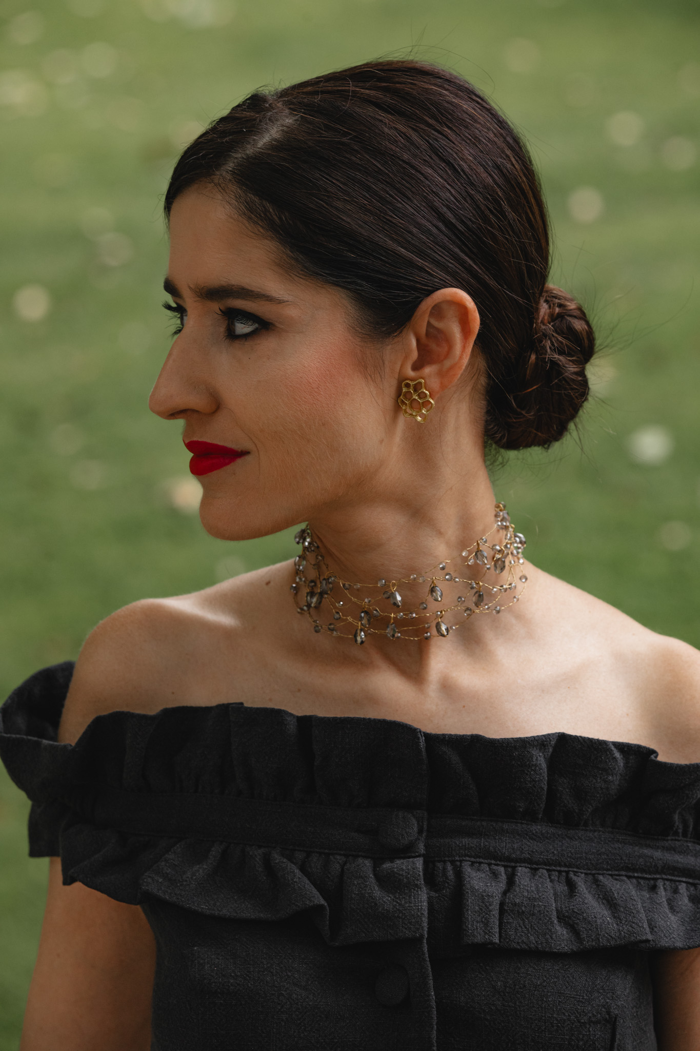 Detalle del collar multicapa y los pendientes dorados con el escote palabra de honor de Cherubina