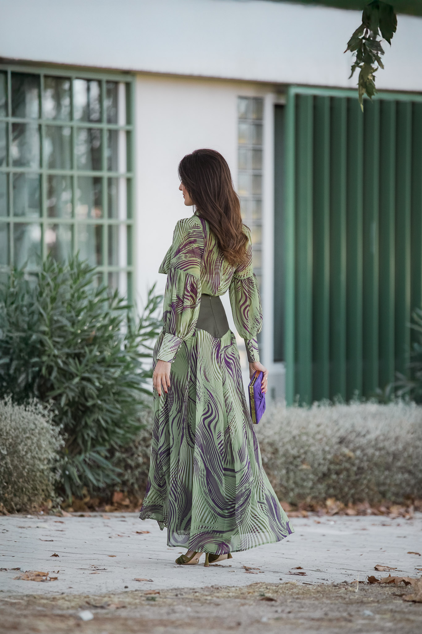 Vuelo de la falda del conjunto verde Magnolia Kobus visto de espaldas, look invitada boda de otoño