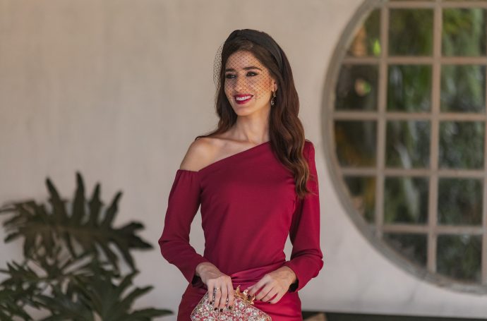 Look de invitada con vestido guinda escote asimétrico en la Quinta de Jarama